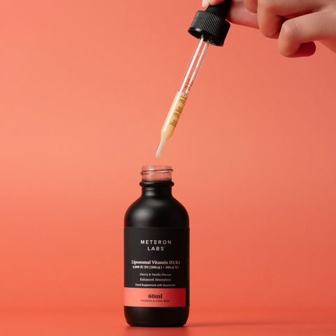 Hand using a dropper to add liquid into a black bottle labeled 'Wethorn' on a red background